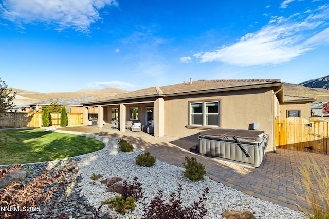 9845 Sea Breeze Ln, Reno, NV 89521 - rear view of property with a hot tub, a mountain view, a patio, and stucco siding