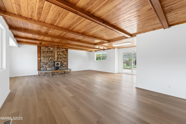 9240 Fremont Way, Reno, NV 89506 - unfurnished living room with wooden ceiling with exposed beams, wood finished floors, a wood stove, and baseboards