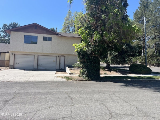 124 Mark Twain Ave, Reno, NV 89509 - view of front facade featuring a garage, concrete driveway, and stucco siding