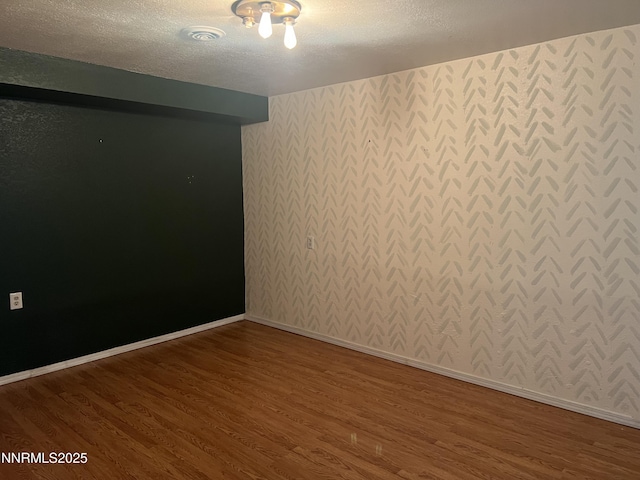 124 Mark Twain Ave, Reno, NV 89509 - spare room with wallpapered walls, wood finished floors, a textured ceiling, and baseboards