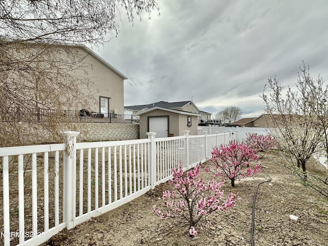 5895 Brooke Dr, Winnemucca, NV 89445 - view of side of home featuring a fenced backyard, an outbuilding, and stucco siding