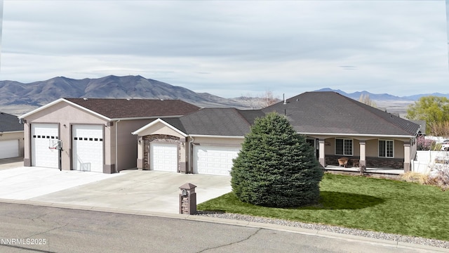 5895 Brooke Dr, Winnemucca, NV 89445 - view of front of house with driveway, a garage, a mountain view, covered porch, and a front lawn