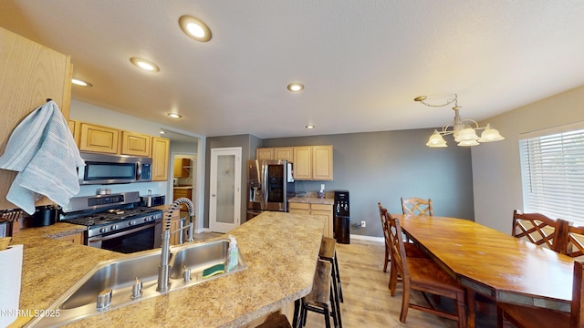 165 W National Ave, Winnemucca, NV 89445 - kitchen with appliances with stainless steel finishes, light brown cabinetry, light countertops, a chandelier, and recessed lighting