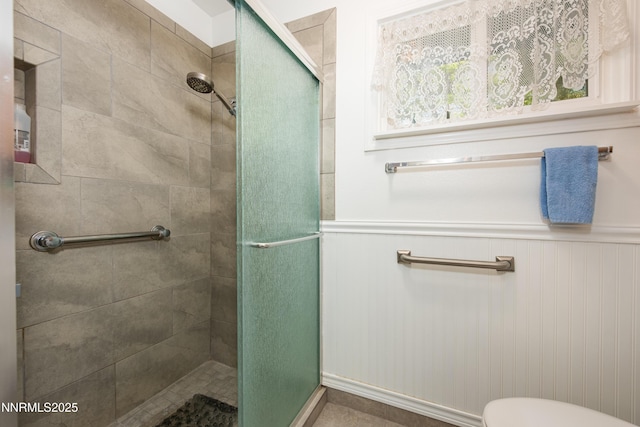 1745 Fir Tree Cir, Minden, NV 89423 - bathroom featuring a stall shower, a wainscoted wall, and toilet