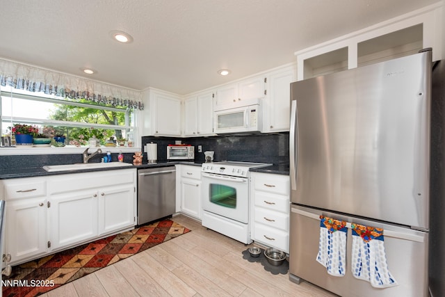 1745 Fir Tree Cir, Minden, NV 89423 - kitchen featuring appliances with stainless steel finishes, a sink, dark countertops, white cabinets, and recessed lighting
