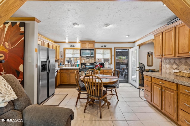 2450 Pinter Ave, South Lake Tahoe, CA 96150 - kitchen featuring appliances with stainless steel finishes, crown molding, tasteful backsplash, light tile patterned floors, and brown cabinets