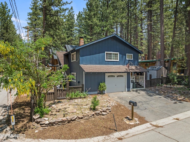 2450 Pinter Ave, South Lake Tahoe, CA 96150 - view of front of house featuring a garage, a chimney, a shingled roof, and concrete driveway