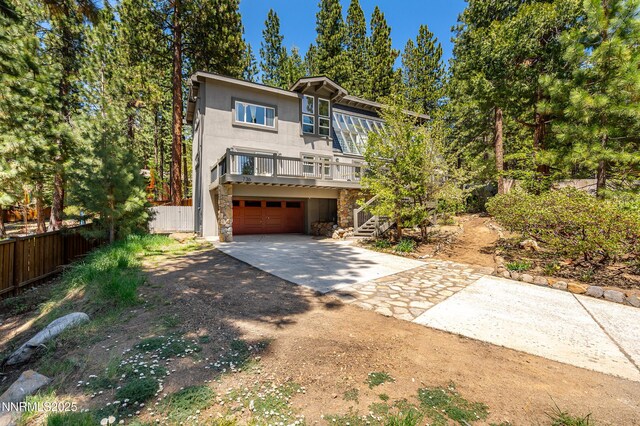 736 Kelly Dr, Incline Village, NV 89451 - view of front facade featuring driveway, stone siding, a garage, stairway, and a wooden deck