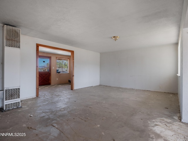 639 Mustang Ln, Gardnerville, NV 89410 - spare room featuring a heating unit and unfinished concrete floors