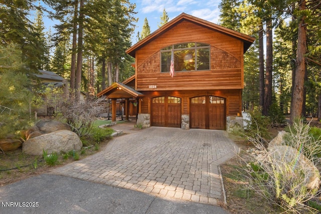 1724 Mohican Dr, South Lake Tahoe, CA 96150 - chalet / cabin with decorative driveway, an attached garage, and stone siding