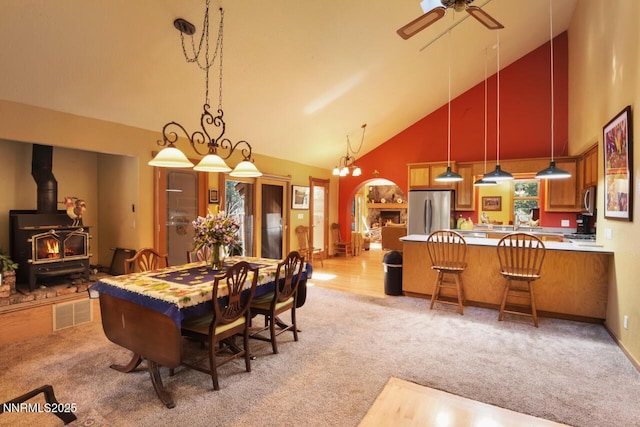 1724 Mohican Dr, South Lake Tahoe, CA 96150 - dining area with high vaulted ceiling, light colored carpet, ceiling fan, and a wood stove