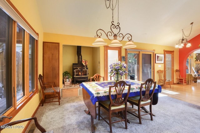 1724 Mohican Dr, South Lake Tahoe, CA 96150 - dining room featuring lofted ceiling, a wood stove, carpet floors, and a chandelier
