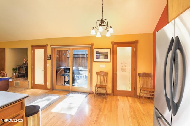 1724 Mohican Dr, South Lake Tahoe, CA 96150 - kitchen featuring freestanding refrigerator, a chandelier, light wood-style floors, pendant lighting, and lofted ceiling
