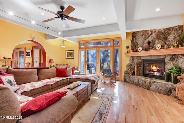 1724 Mohican Dr, South Lake Tahoe, CA 96150 - living room with beam ceiling, wood finished floors, rail lighting, a stone fireplace, and a ceiling fan