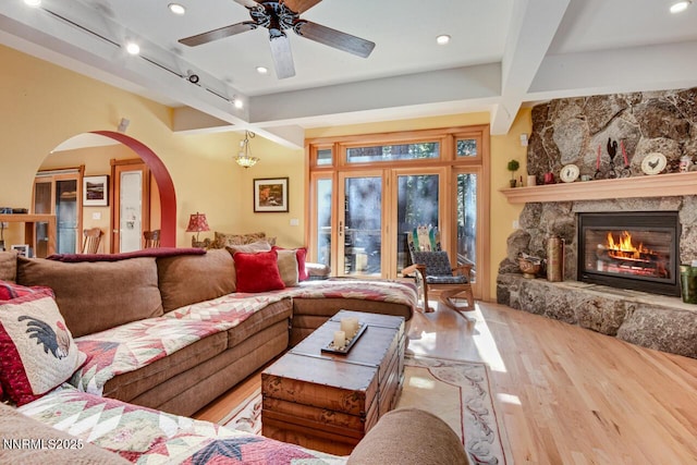 1724 Mohican Dr, South Lake Tahoe, CA 96150 - living area featuring beam ceiling, wood finished floors, arched walkways, a fireplace, and a ceiling fan