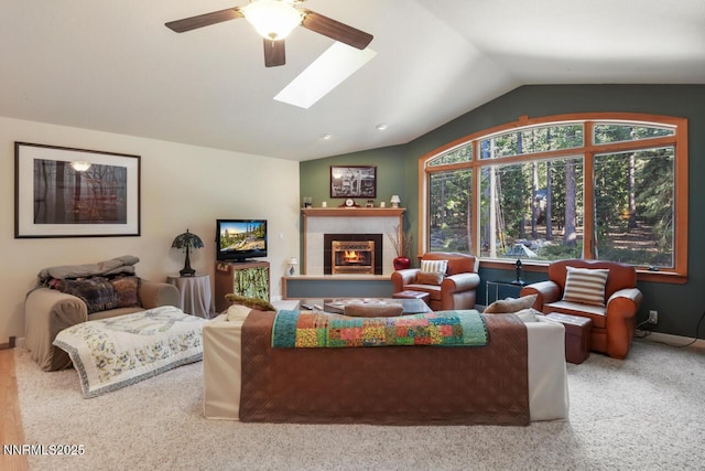 1724 Mohican Dr, South Lake Tahoe, CA 96150 - living room featuring lofted ceiling, a ceiling fan, a tiled fireplace, carpet, and a skylight