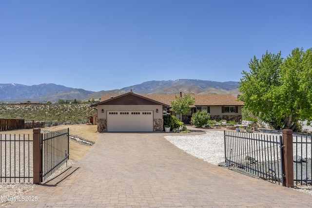 4840 Gentry Ln, Carson City, NV 89701 - ranch-style house with an attached garage, a mountain view, decorative driveway, and a gate