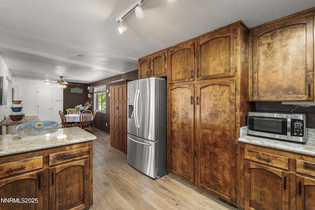4840 Gentry Ln, Carson City, NV 89701 - kitchen featuring appliances with stainless steel finishes, ceiling fan, a textured ceiling, light wood-style floors, and rail lighting