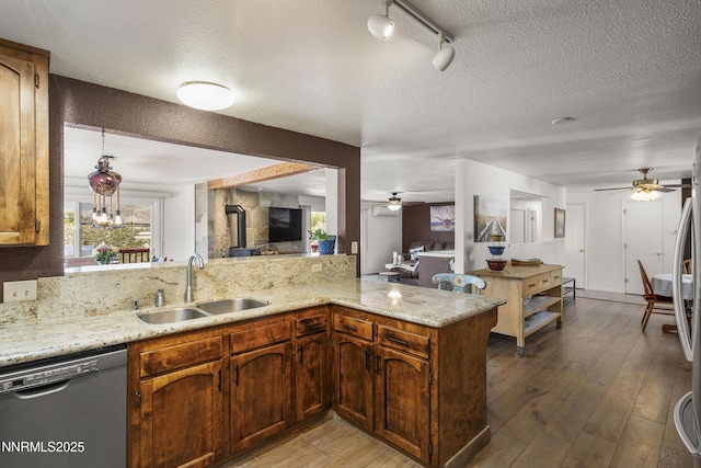 4840 Gentry Ln, Carson City, NV 89701 - kitchen with stainless steel dishwasher, a sink, a ceiling fan, a textured ceiling, and light wood-style floors