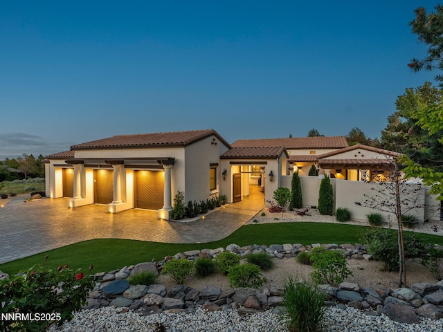 4485 Mountaingate Dr, Reno, NV 89519 - back of house featuring a tile roof, an attached garage, stucco siding, and decorative driveway