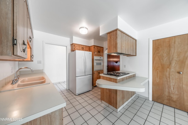 745 Rosewood Dr, Reno, NV 89509 - kitchen with white appliances, a peninsula, a sink, and light countertops
