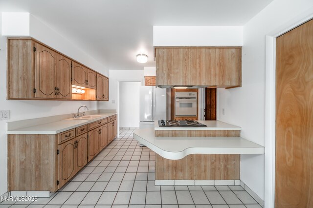 745 Rosewood Dr, Reno, NV 89509 - kitchen with white appliances, a sink, light tile patterned flooring, a peninsula, and light countertops