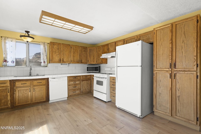 12 S Patterson Pl, Sparks, NV 89436 - kitchen featuring white appliances, under cabinet range hood, a sink, and brown cabinets