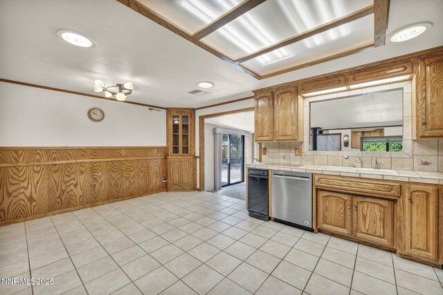 2480 Meadowbrook Ln, Carson City, NV 89701 - kitchen with dishwasher, a sink, wainscoting, brown cabinetry, and wood walls