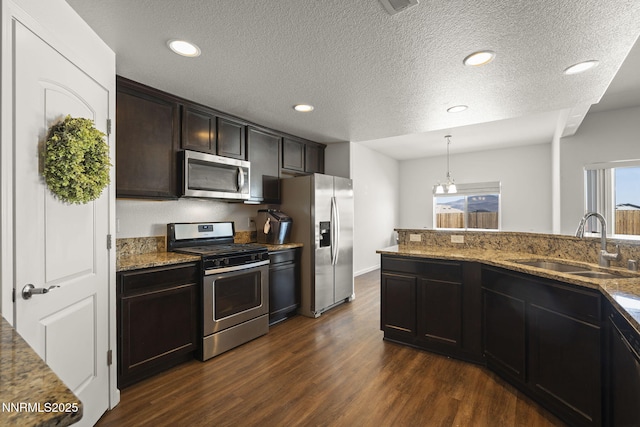 2266 Hayfield Ln, Fernley, NV 89408 - kitchen featuring stainless steel appliances, a sink, dark wood finished floors, light stone countertops, and a textured ceiling