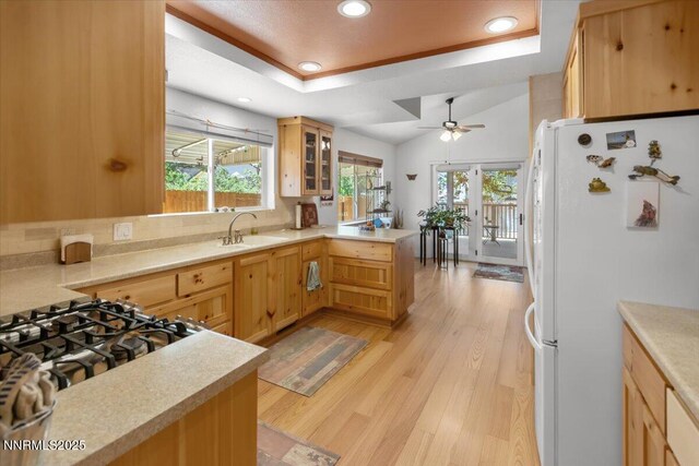 742 Long Valley Rd, Gardnerville, NV 89460 - kitchen featuring freestanding refrigerator, a raised ceiling, a peninsula, a ceiling fan, and light countertops