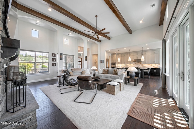 1845 Dove Mountain Ct, Reno, NV 89523 - living area with a stone fireplace, ceiling fan, beam ceiling, a towering ceiling, and dark wood-type flooring