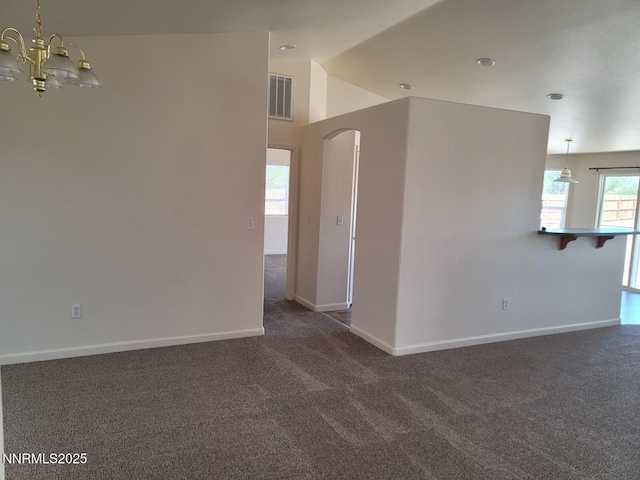 159 Shadow Mountain Dr, Fernley, NV 89408 - spare room featuring dark carpet, a chandelier, arched walkways, lofted ceiling, and baseboards