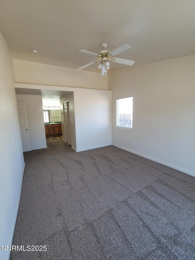 159 Shadow Mountain Dr, Fernley, NV 89408 - empty room featuring a ceiling fan, baseboards, dark carpet, and a smoke detector
