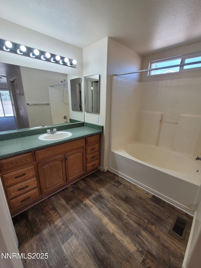 159 Shadow Mountain Dr, Fernley, NV 89408 - bathroom with shower / bathtub combination, vanity, wood finished floors, plenty of natural light, and a textured ceiling