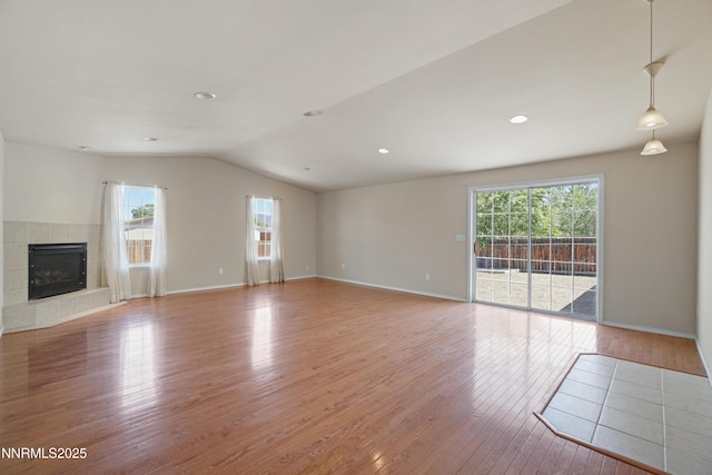 546 Yellow Jacket Rd, Dayton, NV 89403 - unfurnished living room featuring healthy amount of natural light, lofted ceiling, light wood finished floors, a tiled fireplace, and baseboards