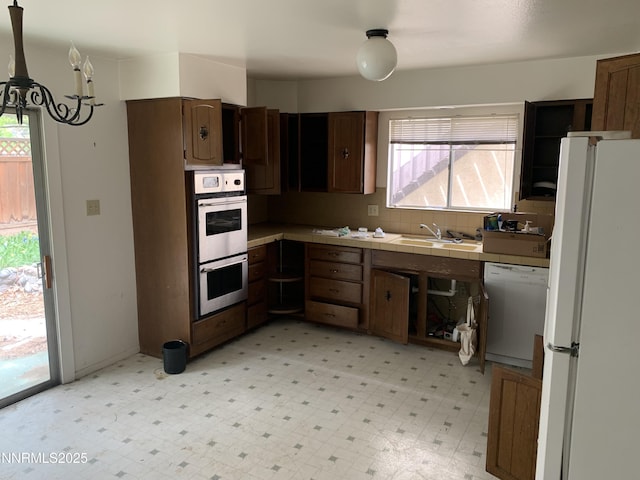 650 John Fremont Dr, Reno, NV 89509 - kitchen with white appliances, tile countertops, a sink, light floors, and a chandelier