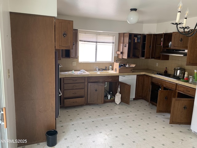 650 John Fremont Dr, Reno, NV 89509 - kitchen with white dishwasher, under cabinet range hood, tile counters, electric stovetop, and tasteful backsplash