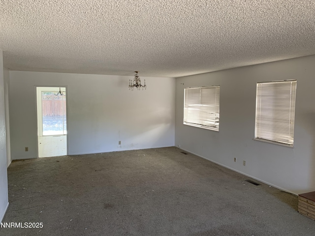 650 John Fremont Dr, Reno, NV 89509 - carpeted spare room with a textured ceiling, a chandelier, and healthy amount of natural light