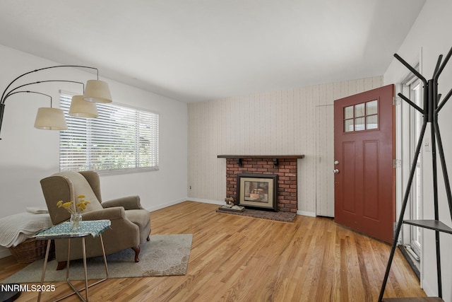 633 Crain St, Carson City, NV 89703 - living area featuring baseboards, wood finished floors, wallpapered walls, and a brick fireplace