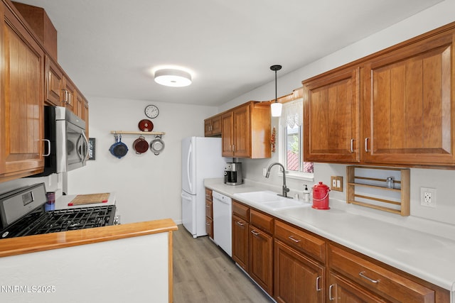 633 Crain St, Carson City, NV 89703 - kitchen with a sink, appliances with stainless steel finishes, light wood finished floors, light countertops, and brown cabinetry