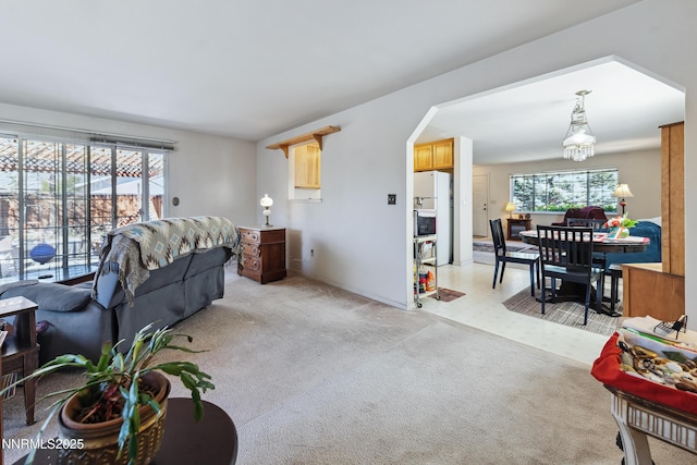 1667 Spooner Dr, Carson City, NV 89706 - living area with arched walkways, light carpet, baseboards, and a chandelier