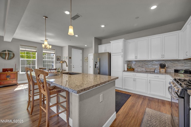 1940 Dark Horse Rd Unit C, Reno, NV 89521 - kitchen featuring stainless steel appliances, a sink, light stone countertops, dark wood-style floors, and white cabinets