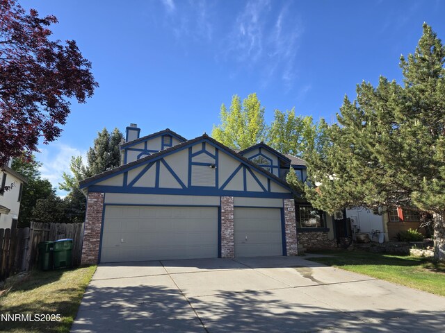 986 Quail Hollow Dr, Reno, NV 89511 - tudor house with driveway, an attached garage, a chimney, stucco siding, and brick siding