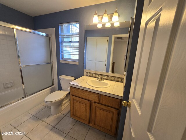986 Quail Hollow Dr, Reno, NV 89511 - bathroom with vanity, tile patterned flooring, toilet, and bath / shower combo with glass door