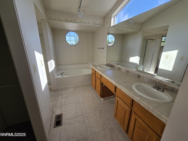 986 Quail Hollow Dr, Reno, NV 89511 - bathroom with rail lighting, a garden tub, double vanity, a stall shower, and tile patterned floors