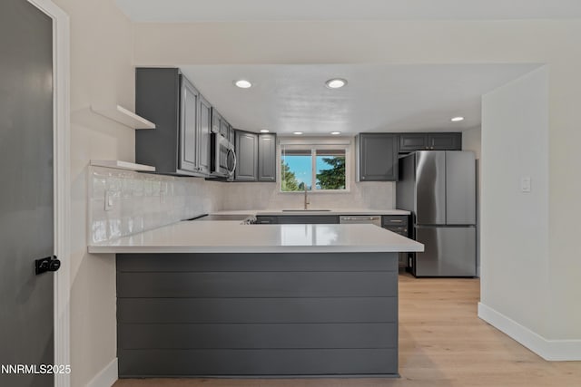 583 Marta Way, Reno, NV 89503 - kitchen with stainless steel appliances, open shelves, a peninsula, baseboards, and backsplash