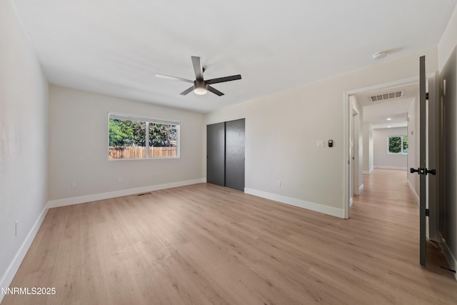 583 Marta Way, Reno, NV 89503 - unfurnished bedroom featuring multiple windows, light wood-type flooring, and a closet