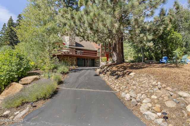 968 Pyrite Ct, Incline Village, NV 89451 - view of front facade featuring stone siding, a garage, a wooden deck, and asphalt driveway