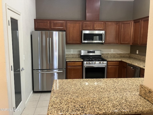 5619 Crescent Hill Way, Sparks, NV 89436 - kitchen with stainless steel appliances, light tile patterned floors, light stone countertops, and a peninsula