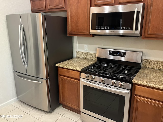 5619 Crescent Hill Way, Sparks, NV 89436 - kitchen featuring stainless steel appliances, light tile patterned floors, light stone countertops, and brown cabinets